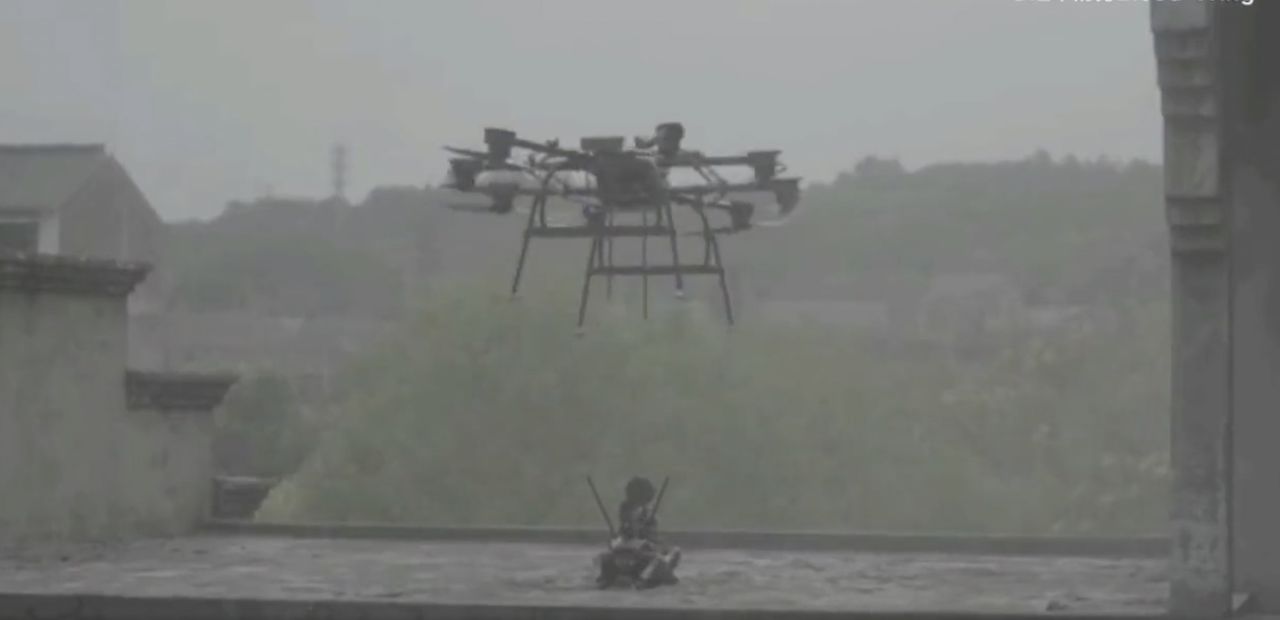 Kolla in när drönare lämnar av beväpnad robothund