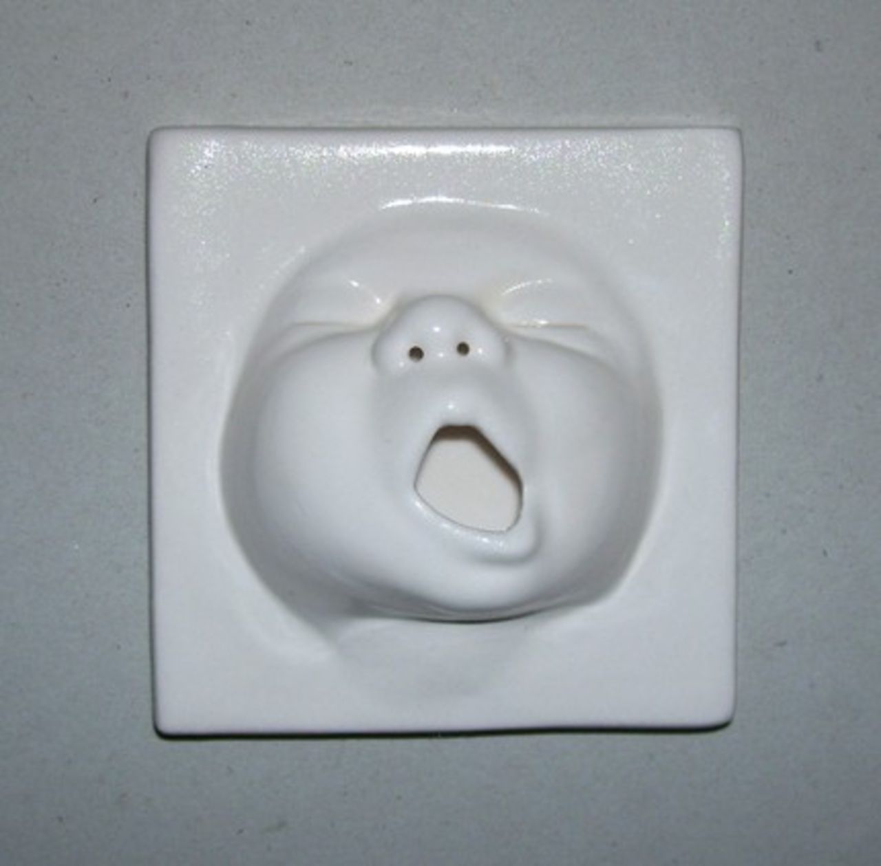 Kakelplatta med bebisansikte